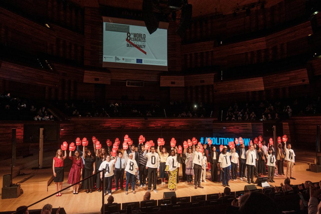 Youth delegates on stage performing the #ABOLITION NOW demonstration at the World Congress Against the Death Penalty